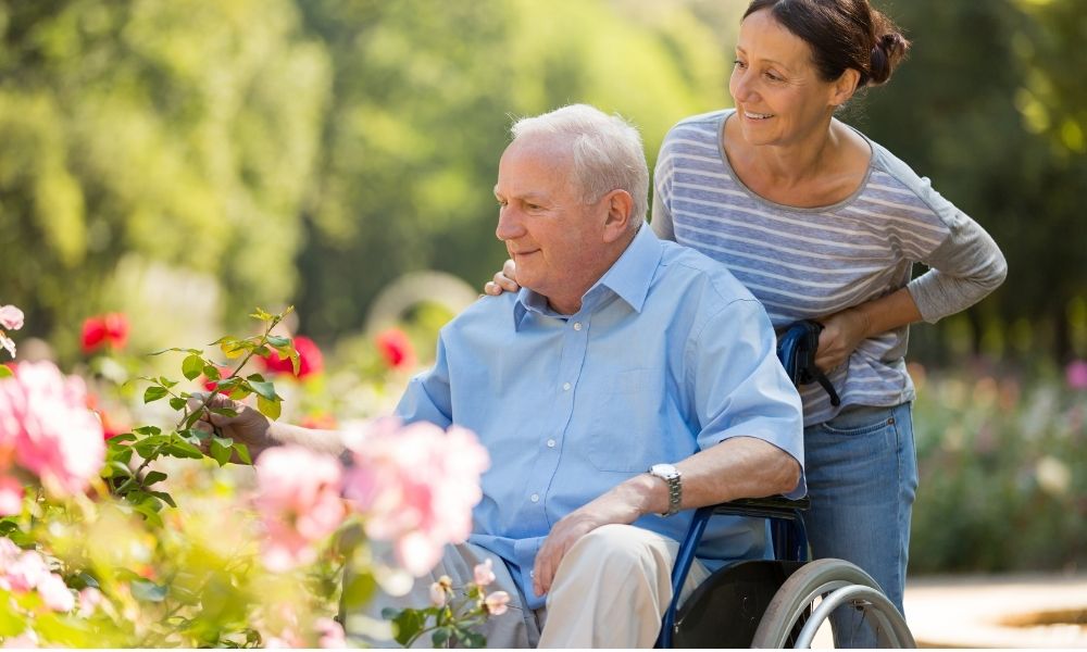 caregiver pushing an older adult in a wheelchair