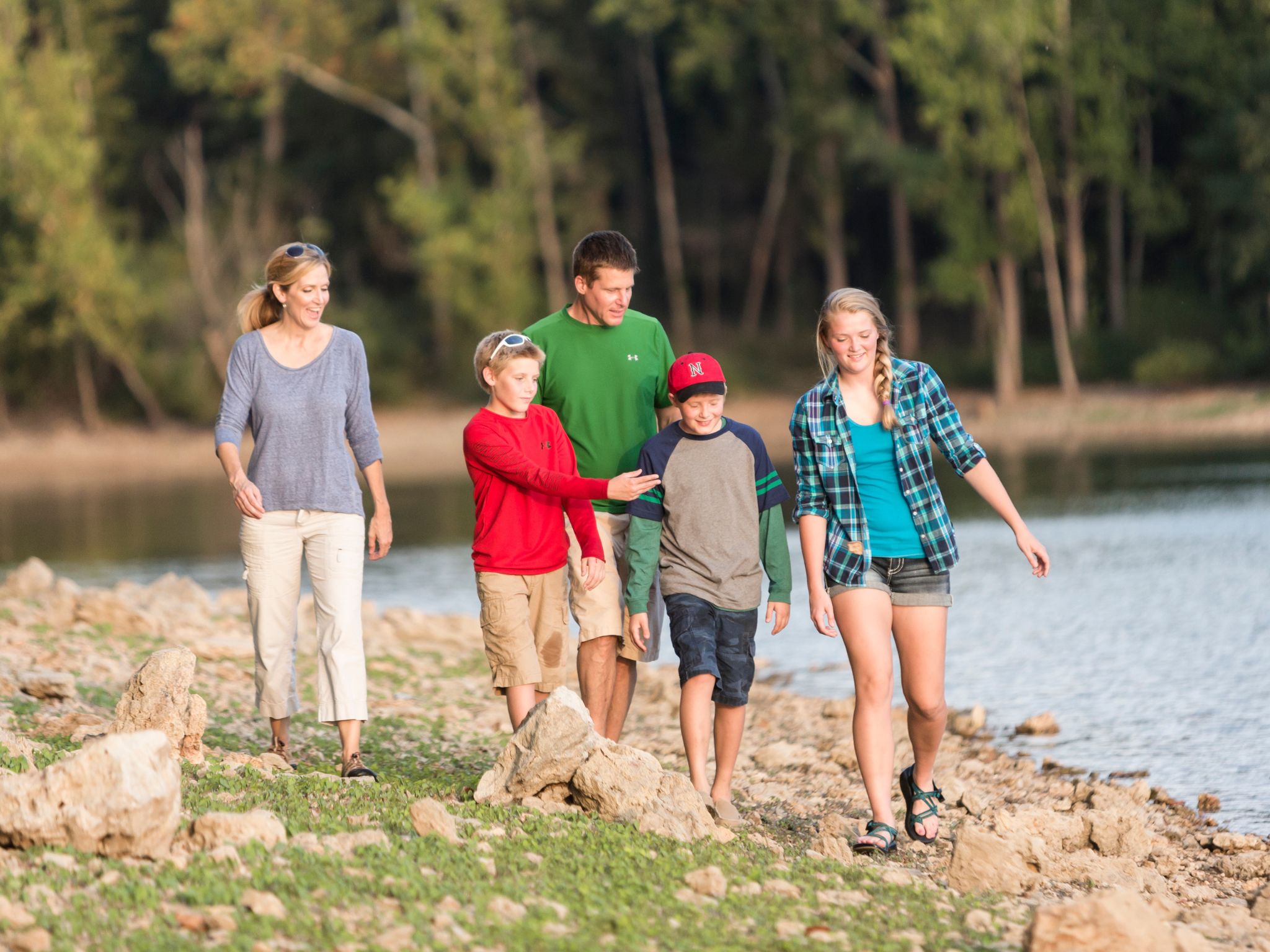 Family walking on the bank of a lake.
